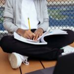 Enfant écrivant dans un cahier avec un crayon