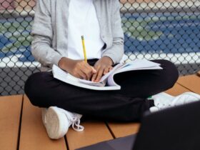 Enfant écrivant dans un cahier avec un crayon