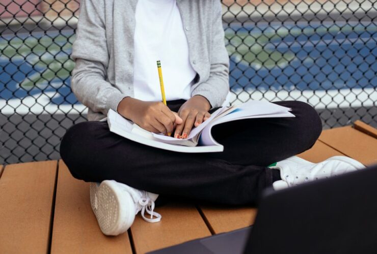 Enfant écrivant dans un cahier avec un crayon